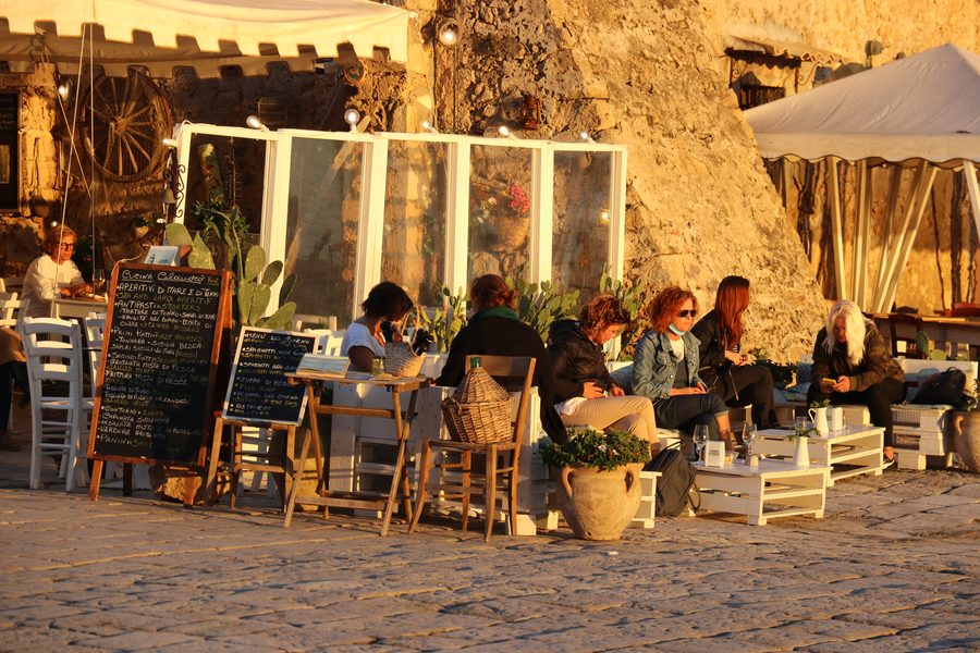 Outdoor restaurant at golden hour on Sicilian cobblestones, Sicily, Italy